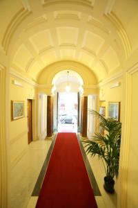 罗马丘丘酒店的一条铺有红地毯的大走廊和一条红色的走道