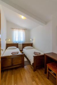 梅德詹Villa Lavanda的客房内设有两张床,铺有木地板,设有窗户。