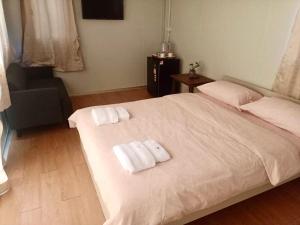 大城Homey Hut Ayutthaya的卧室配有带毛巾的大型白色床