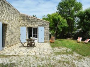 莱斯波特斯Maison cosy près du centre des Portes-en-Ré, 2 chambres, forfait ménage inclus - FR-1-434-73的庭院里配有桌椅