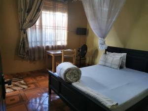 NjeruThe Roots classic hotel的一间卧室设有一张大床和一个窗户。