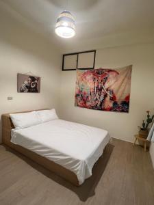 小琉球岛暖流背包客栈的一间卧室配有一张壁画床