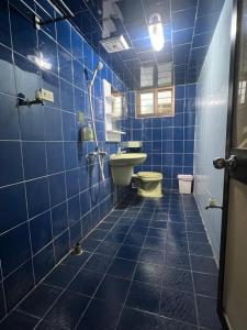 小琉球岛暖流背包客栈的蓝色瓷砖浴室设有卫生间和水槽