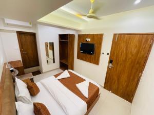 孟买HOTEL BLACK BURN的卧室配有一张床,墙上配有电视。