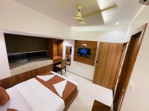 孟买HOTEL BLACK BURN的一间酒店客房,配有一张床和一台电视