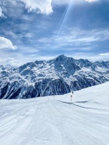 索尔登阿尔盆黑姆西蒙娜酒店的一个人在雪覆盖的山里滑雪