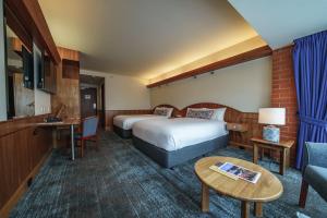 阿德莱德阿卡巴酒店的酒店客房设有两张床、一张沙发和一张桌子。