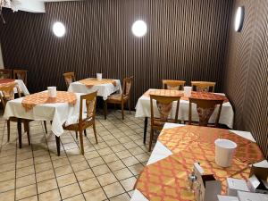 胡根尔舍姆Hotel Schwan的一间在房间内配有桌椅的餐厅