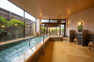 天童市宜居鹤屋日式旅馆的一座带大窗户的建筑中的游泳池