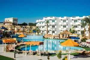 沙姆沙伊赫Palma Di Sharm Hollywood Aqua Park Resort的一个带遮阳伞和椅子的游泳池以及建筑