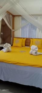新加拉惹Sekumpul BnB的黄色的床,上面有两条毛巾