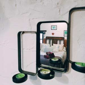 米耶雷斯La Nozal - La Vallicuerra Casas Rurales的一张桌子上两面镜子,房间里还有一张床