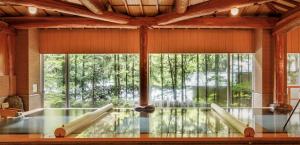 仙台作并温泉沙龙位置墓酒店的大型客房设有游泳池和大窗户