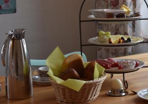 达默Hotel Sonnenschein - Spielerei im Sonnenschein的桌上的面包和水果篮,带温热器