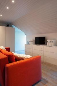 根特B&B Maison Blanche的客厅配有橙色沙发和电视