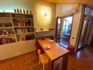 伊莫拉Matrioska House B&B的一间带木桌和书架的用餐室