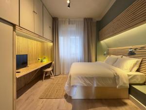 塞萨洛尼基#Infinity & Beyond seafront apts, amazing view的一间卧室配有一张床、一张书桌和一台电视