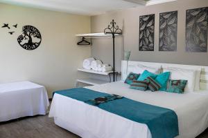阿拉亚尔-杜卡布Pousada Estalagem dos Corais da Prainha的卧室配有带蓝色枕头的大型白色床