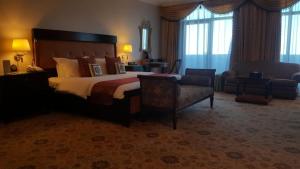 艾卜哈艾卜哈宫大酒店的酒店客房带一张大床和一把椅子
