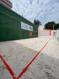 伊图佩瓦Hotel ITR-SPA的网球场被橙色围栏覆盖在沙子中