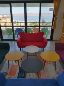 提比里亚turtle guesthouse- tiberias的客厅配有桌子和红色沙发