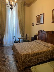 佛罗伦萨别墅利亚纳酒店的酒店客房配有一张床铺和一张桌子。