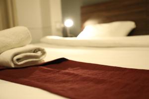 安曼The Sydney Hotel的酒店客房,配有带毛巾的床