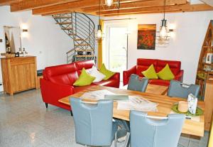 奥斯赛拜-塞林Ferienwohnung Selliner Strand的一间带桌子和红色椅子的用餐室