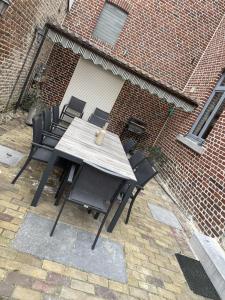 比尔曾Vakantiewoning Bij de Jep的砖砌建筑前的木桌和椅子