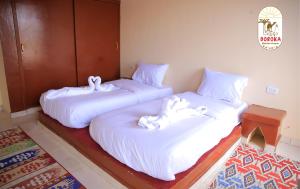 ShellalDoroKa Nubian House的两张睡床彼此相邻,位于一个房间里