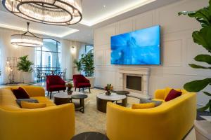 海法Hotel Botanica- Limited Edition By Fattal的客厅设有黄色椅子和壁炉