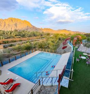 SharīyahRed_Hut_Resort的享有游泳池的顶部景色,游泳池背景为群山