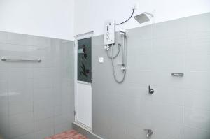 达瓦拉维Clay House的浴室铺有白色瓷砖,设有淋浴。