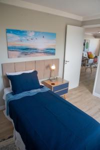 圣路易斯Ap Cozy Calhau prox PRAIA的一间带蓝色床的卧室和一间客厅