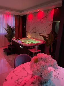 索恩河畔沙隆NUITS D'HERMES & Spa的一间带桌子和鲜花的浴缸的客房