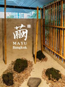 曼谷MAYU Bangkok Japanese Style Hotel的前面有岩石的玛柳树 ⁇ 标志