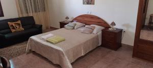 波多诺伏Residencial Chez Flor的一间卧室配有一张大床和一张沙发