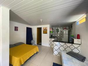 卡博迪圣阿戈斯蒂尼奥Casa na Orla - Praia de Gaibu!的一间带黄色床的卧室和一间厨房