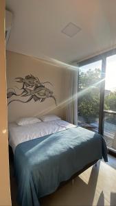 马利西亚斯Pousada Low Tide maresias的卧室配有一张挂有鱼画的床铺。