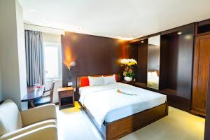 胡志明市Bonka Hotel Luxury Quận 5 HCM的一间卧室配有一张床、一张桌子和一张沙发
