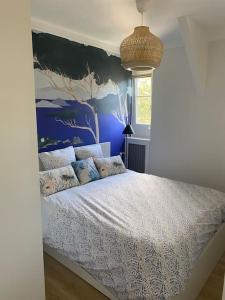 拉波勒APPARTEMENT REFAIT A NEUF, IDEALEMENT SITUÉ的一间卧室配有一张蓝色墙壁的床