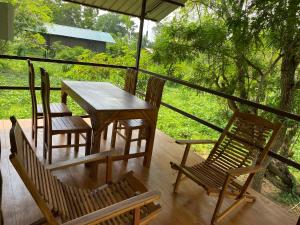 Nekattegamamango villa wilpattu的享有森林景致的门廊上的桌椅