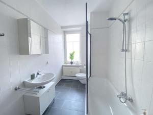 莱比锡Stilvolle 2 Zimmer Wohnung mit Küche, TV, Waschmaschine的白色的浴室设有水槽和淋浴。