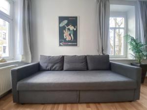 莱比锡Stilvolle 2 Zimmer Wohnung mit Küche, TV, Waschmaschine的客厅设有灰色沙发,配有窗户