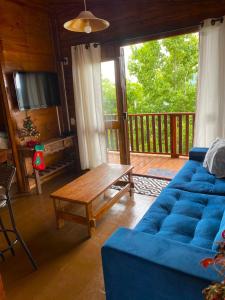 格拉玛多Cabana Alto do Monte的客厅配有蓝色的沙发和木桌