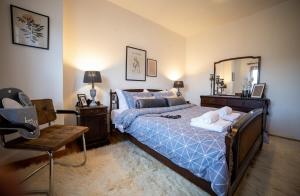 Villa Pallas的一间卧室配有一张带镜子和椅子的床