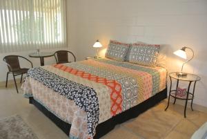 博雷戈斯普林斯Borrego Springs Motel的一间卧室配有一张带两张桌子和两盏灯的床。