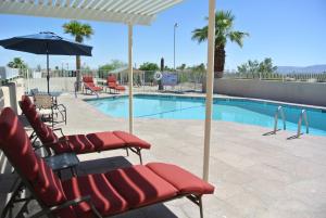 博雷戈斯普林斯Borrego Springs Motel的游泳池旁的游泳池配有椅子和遮阳伞