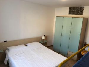 科雷多Appartamento Rosa的一间卧室配有一张床和一个绿色的橱柜