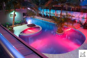阿克拉Mendiata Hotel的度假村内带粉红色灯的游泳池